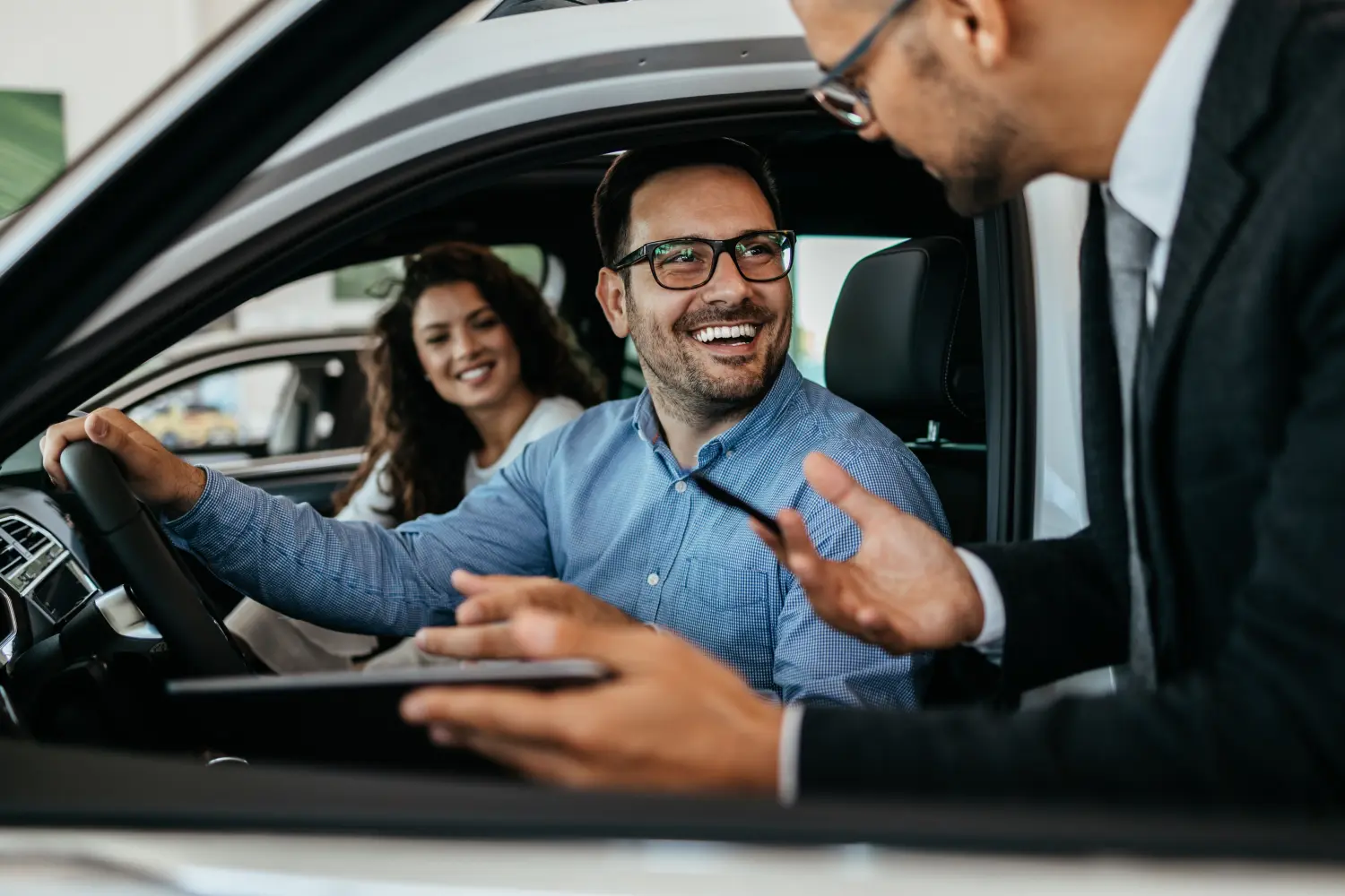 Paar wählt und kauft Auto im Autohaus mit Autohändler